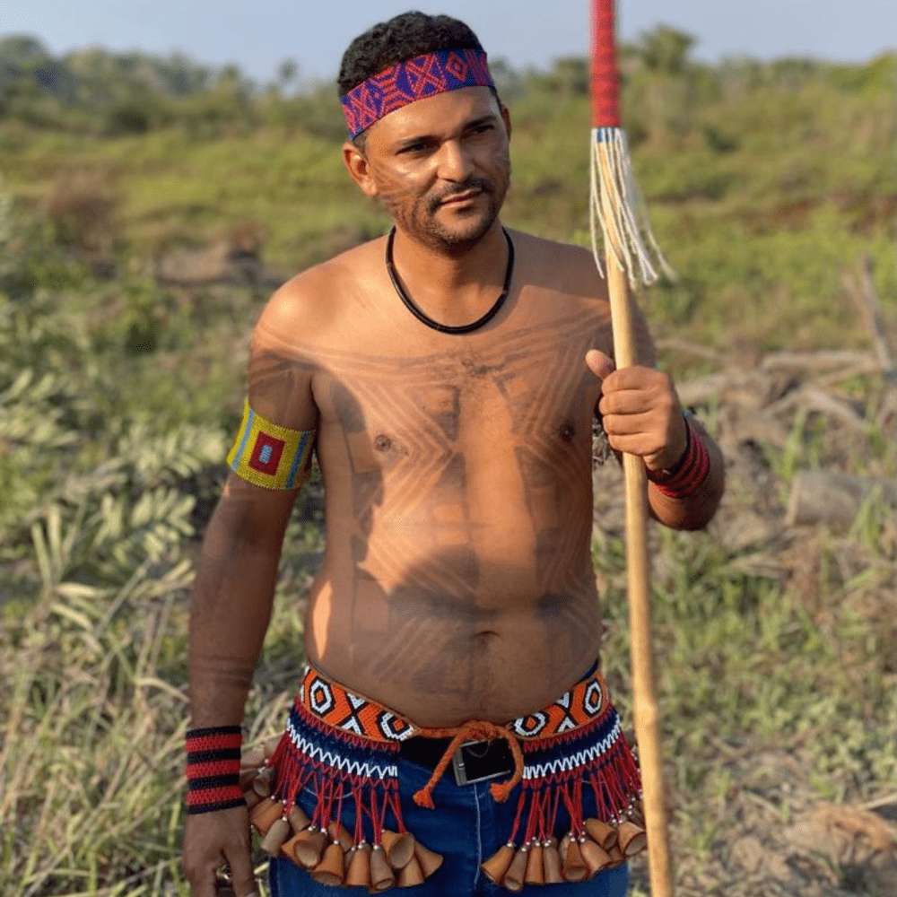 jeune homme avec des habilles traditionnelles d'indigènes brésiliennes, torse nu avec peinture sur le corps