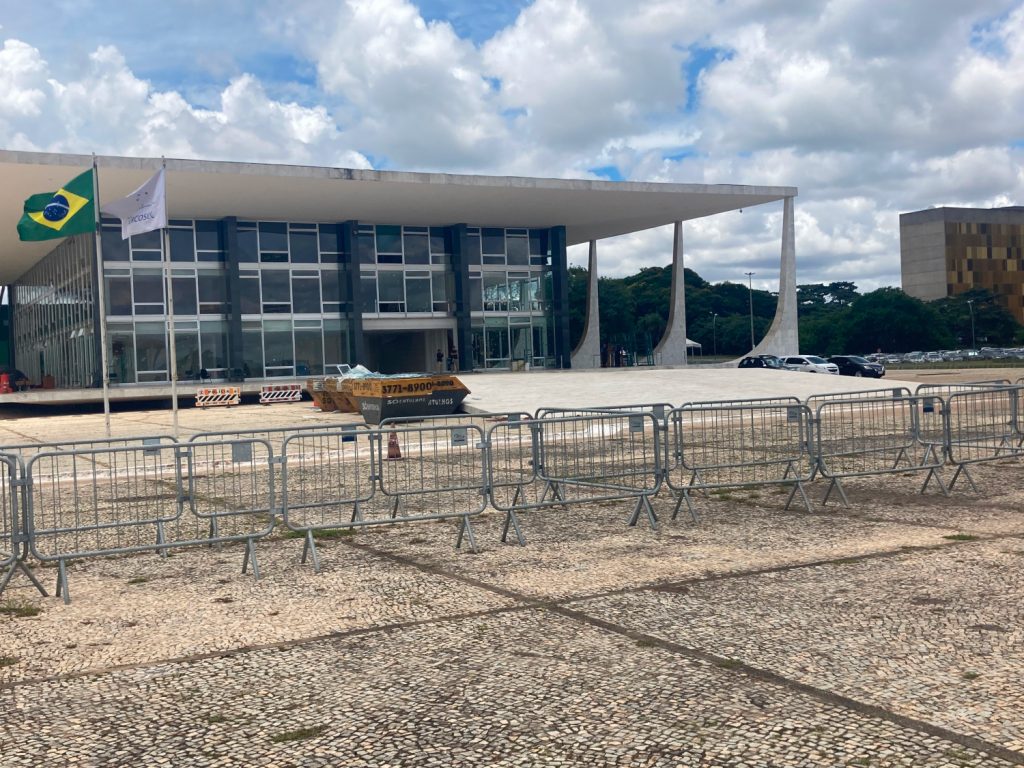 barrières de chantier devant un bâtiment de bureau avec le drapeau brésilien