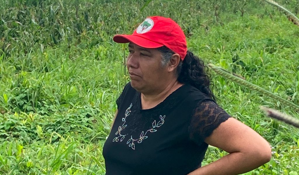 Femme avec une casquette rouge dans devant un champs vert