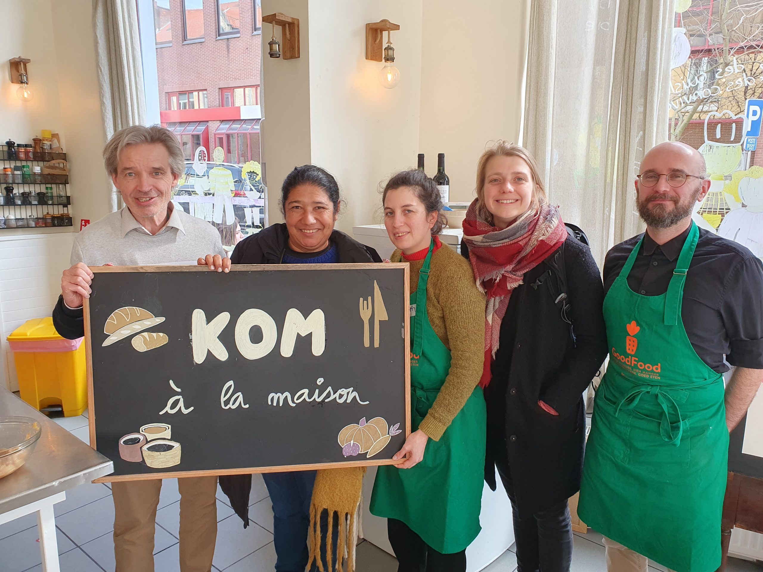 Photo de groupe de 5 personnes dont Maria Moreira Da Silva, ils tiennent un panneau "KOM à la maison"