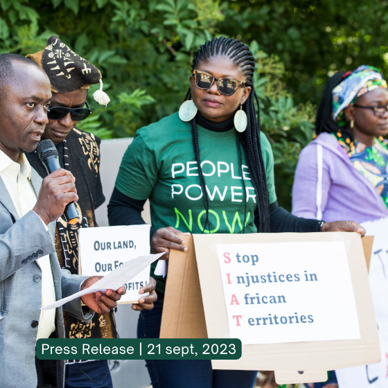 Un groupe de manifestatants avec des pancartes. Une est lisible : Stop Injustice in African Territories