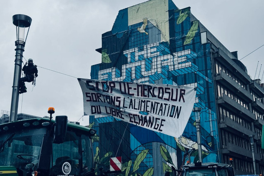 Une banderole "Stop UE-Mercosur" devant une frèsque murale avec les mots "The future"