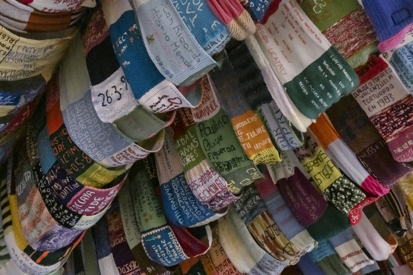 Une multitude de bandeaux en tissu avec des nom et des dates brodés