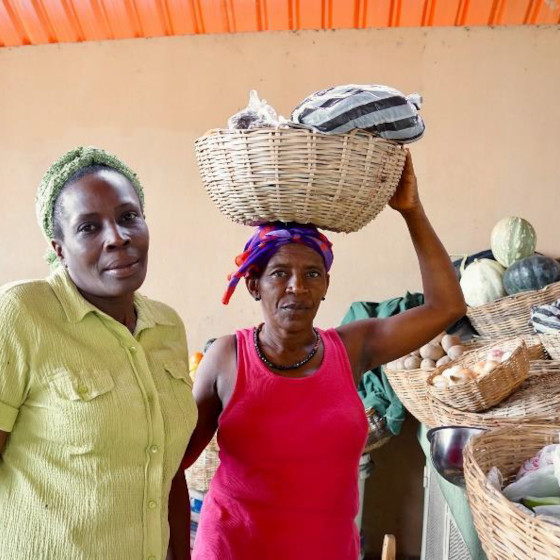 Deux femmes devant des paniers de légumes