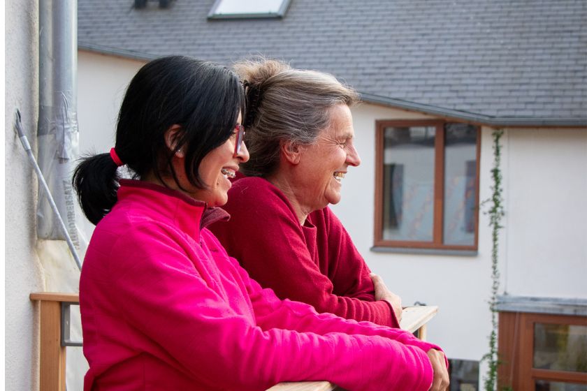 Deux femmes étant appuyer sur un balcon et regardant l'horizon