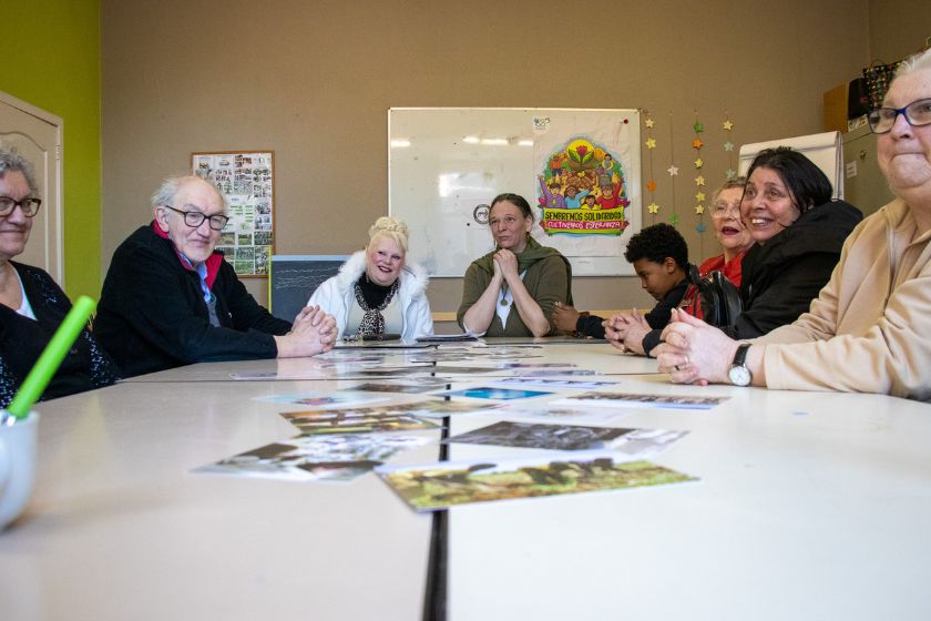 Un groupe de personnes autours d'une table regardant la caméra