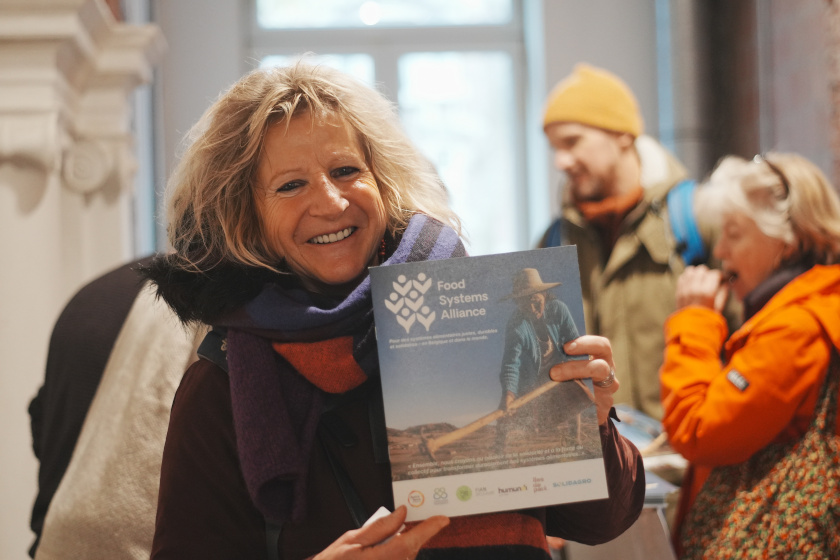 Une personne montre une affiche : Food Systems Alliance