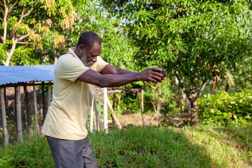 Un homme tient du compost dans ses mains