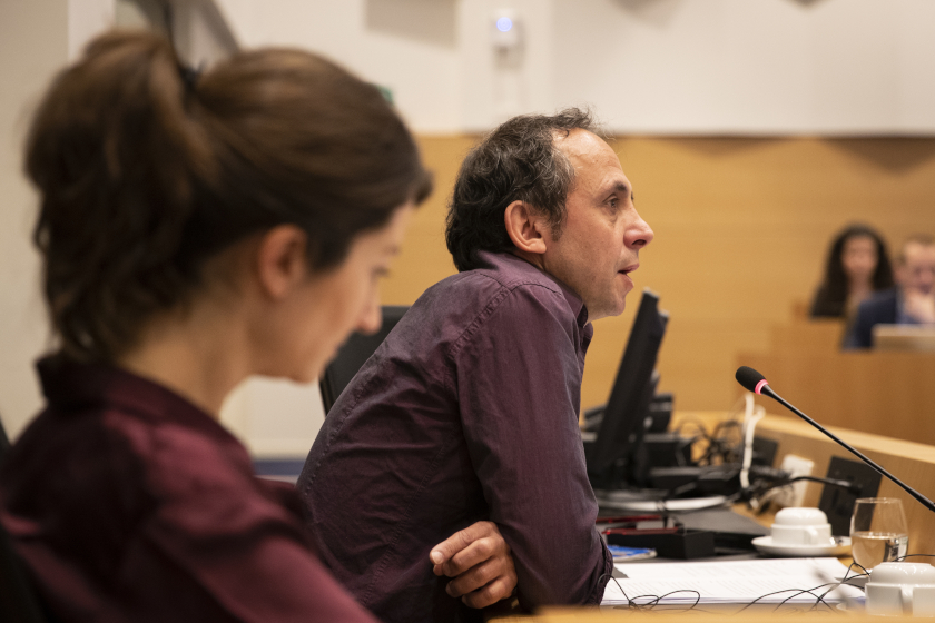 Un homme parle devant un public hors champs