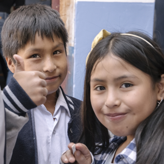 Deux enfants souriants, un lève le pouce