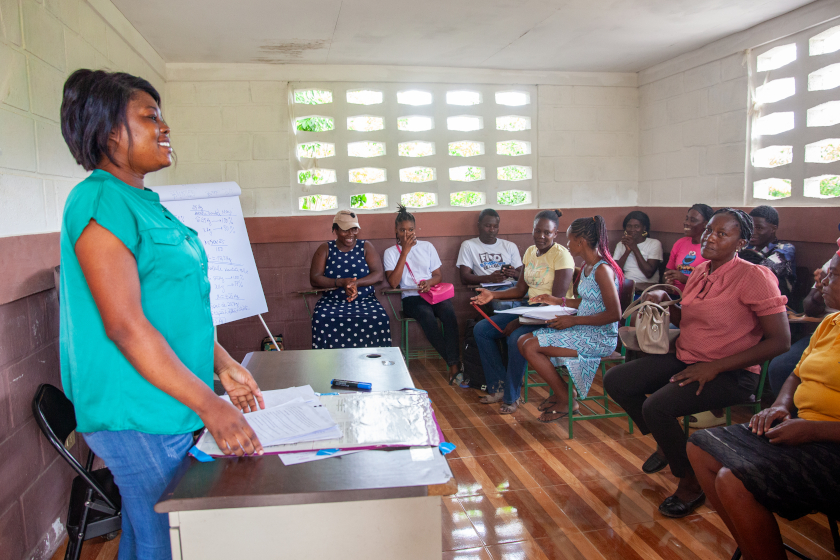 Une femme parle devant une assemblée de femmes