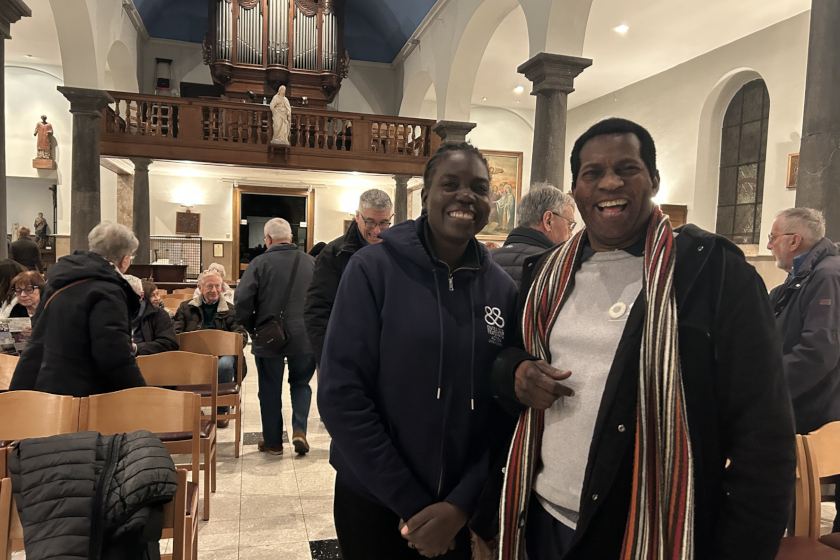 Deux personnes souriantes dans une église. Derrière eux d'autres personnes en train de chercher une place. A l'arrière plan un orgue